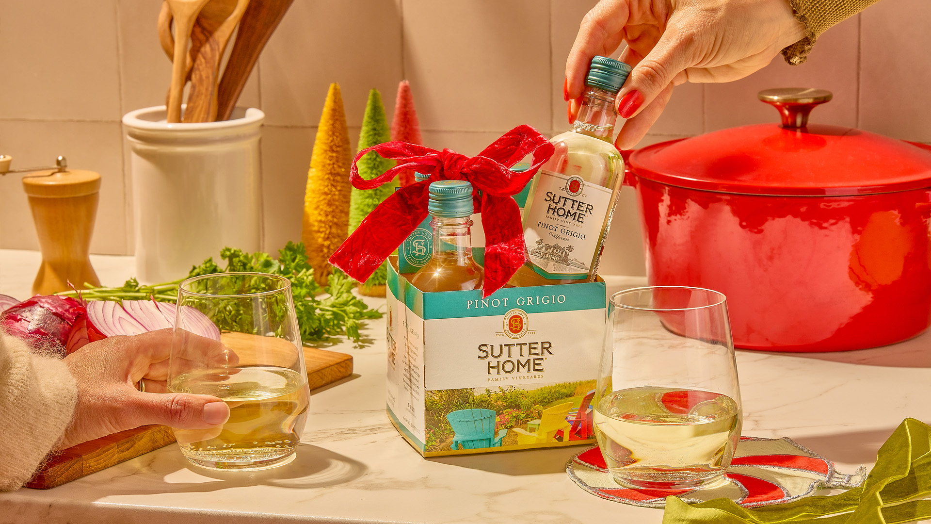 A table with a 4-pack of Sutter Home Cabernet Sauvignon mini bottles, a football, and a stadium blanket in the background - multiple items needed to take to the big game.